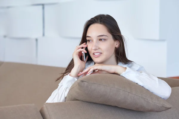 Mujer joven usando el teléfono celular en casa — Foto de Stock