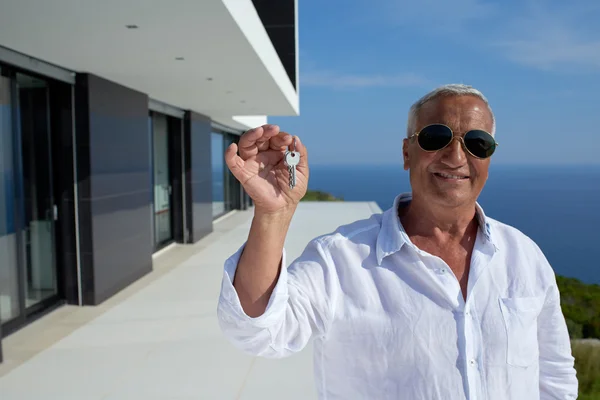 Hombre mayor frente a la casa moderna —  Fotos de Stock