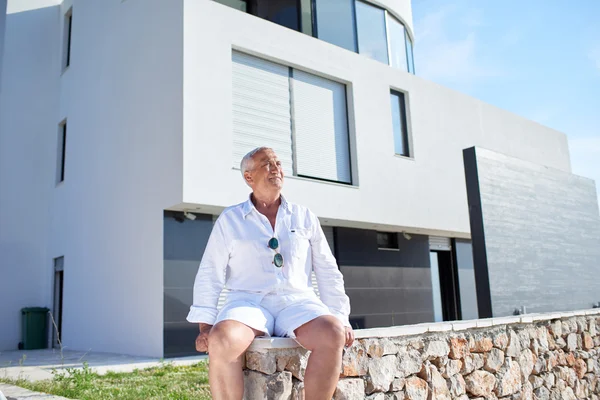 Homem sênior na frente da casa moderna — Fotografia de Stock