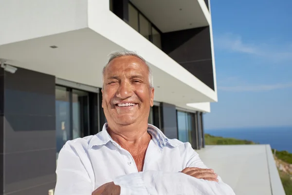 Senior man voor modern huis — Stockfoto
