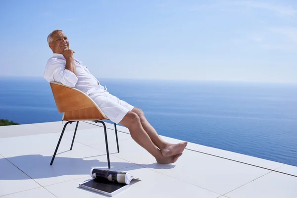 Senior man in front of modern home — Stock Photo, Image