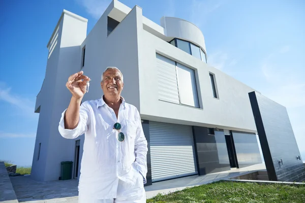 Hombre mayor frente a la casa moderna — Foto de Stock