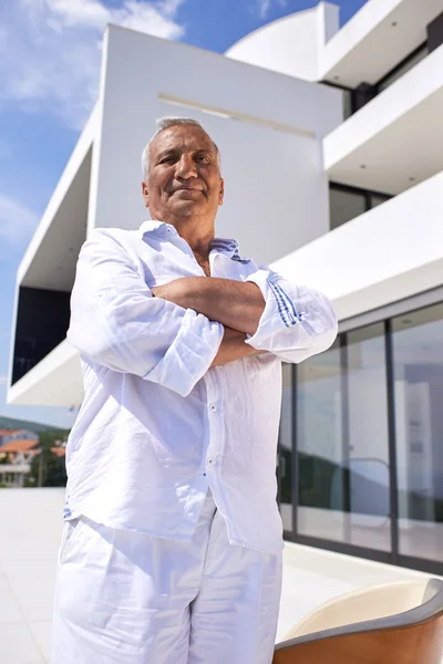 Hombre mayor frente a la casa moderna — Foto de Stock