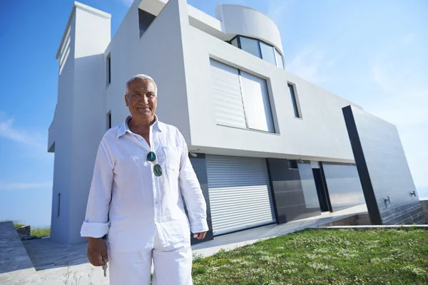 Hombre mayor frente a la casa moderna — Foto de Stock