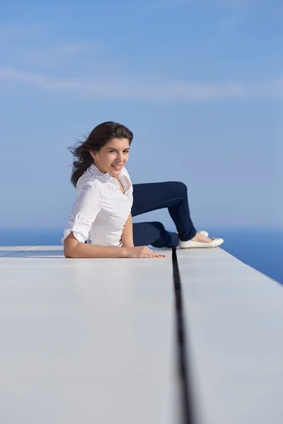 Relaxed woman in front of luxury modern home — Stock Photo, Image