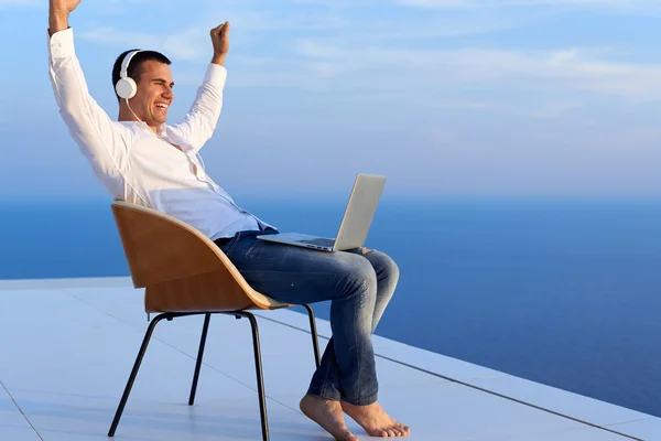 Relaxed young man at home on balcony — Stock Photo, Image