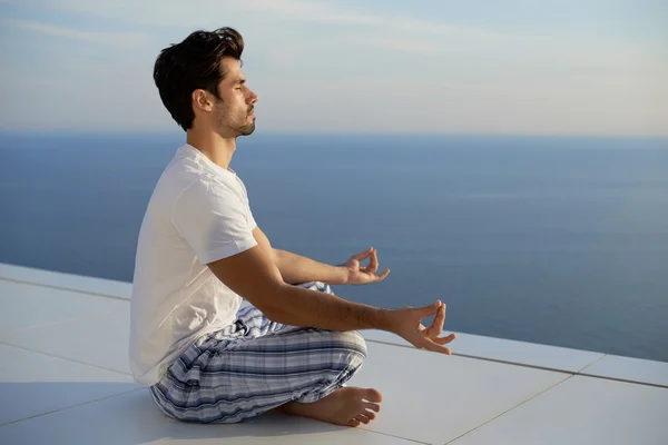 Junger Mann praktiziert Yoga — Stockfoto