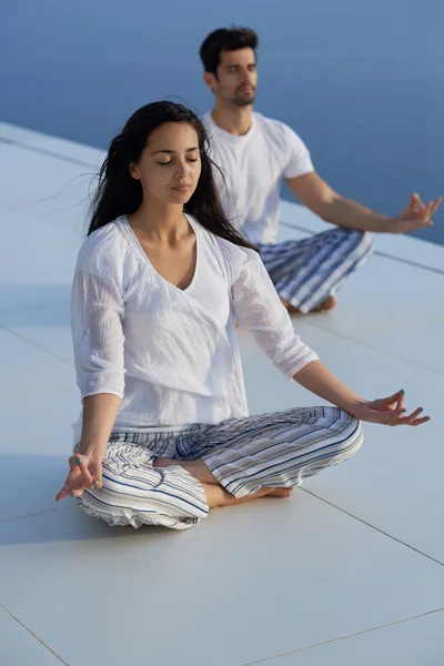 Pareja joven practicando yoga — Foto de Stock