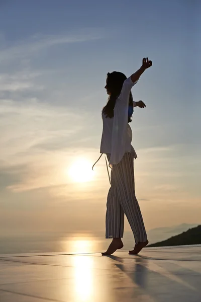 Jovem mulher ao pôr do sol — Fotografia de Stock