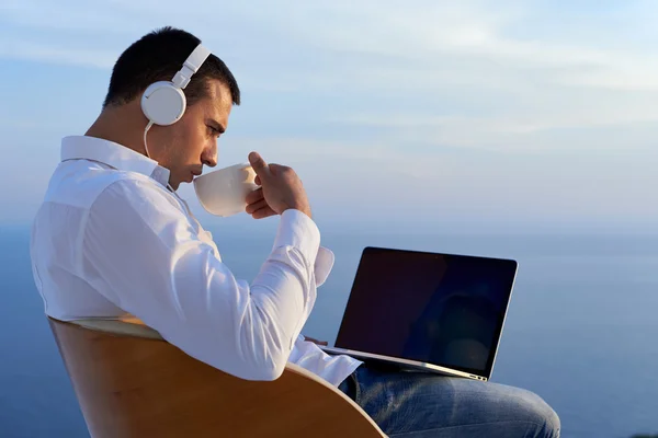 Relaxed young man at home on balcony — Stock Photo, Image