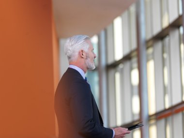 Tablet bilgisayarda çalışan üst düzey iş adamı