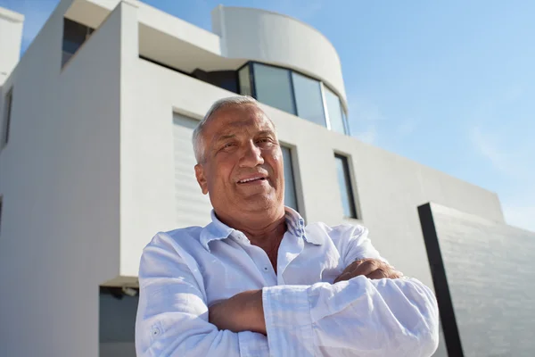 Hombre mayor frente a la casa moderna — Foto de Stock