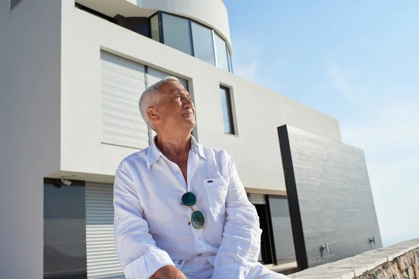 Hombre mayor frente a la casa moderna —  Fotos de Stock