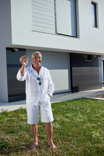 Senior man in front of modern home — Stock Photo, Image