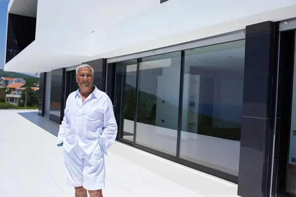 Hombre mayor frente a la casa moderna — Foto de Stock