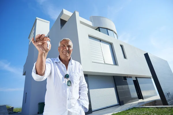 Hombre mayor frente a la casa moderna — Foto de Stock