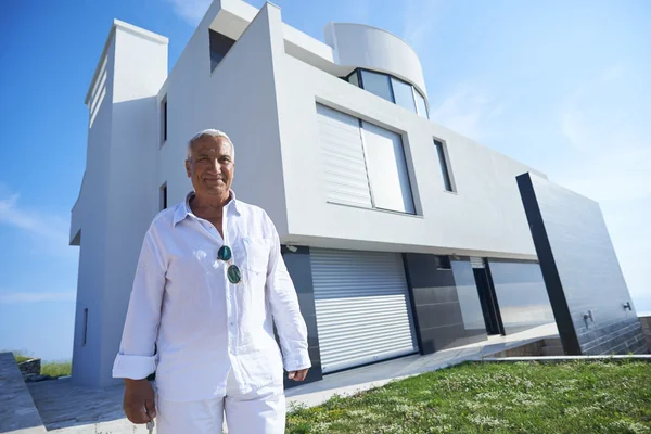 Homem sênior na frente da casa moderna — Fotografia de Stock