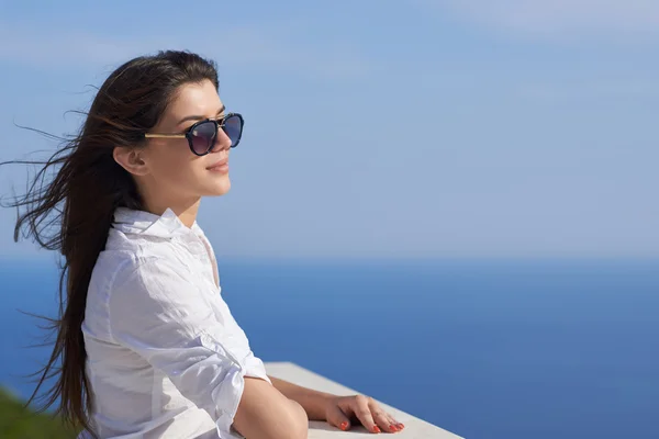 Relaxed woman in front of luxury modern home — Stock Photo, Image