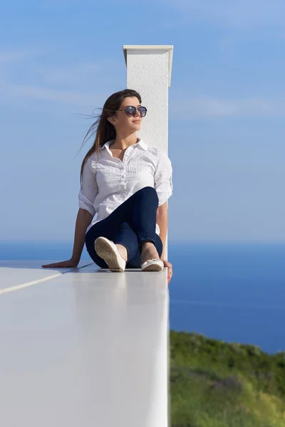 Entspannte Frau vor luxuriösem, modernem Haus — Stockfoto