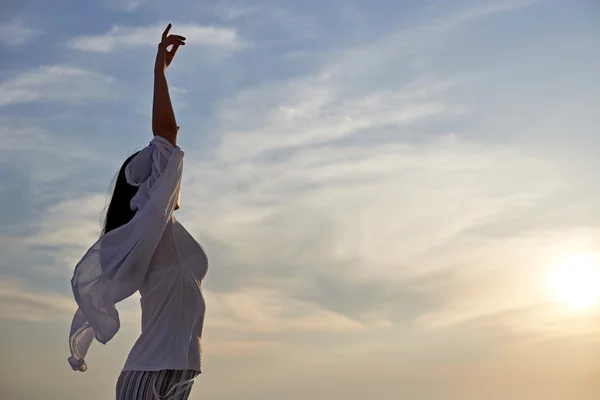 Jonge vrouw bij zonsondergang — Stockfoto