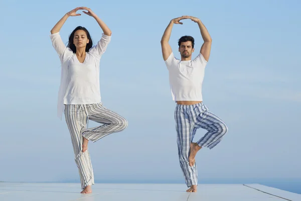 Pareja joven practicando yoga —  Fotos de Stock