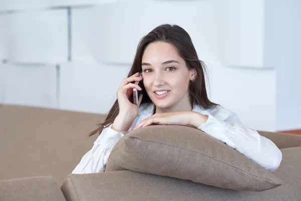 Mujer joven usando el teléfono celular en casa — Foto de Stock