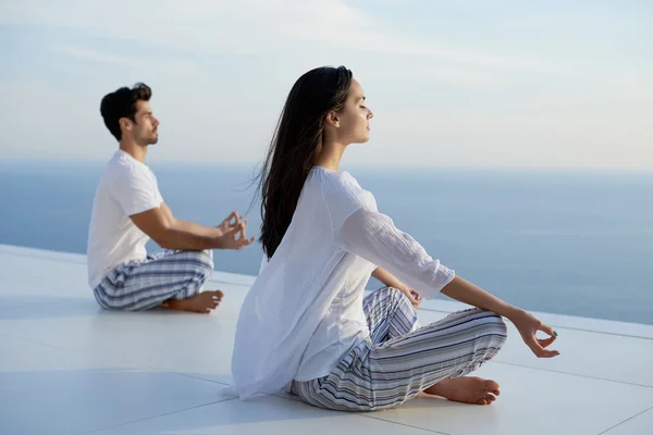 Pareja joven practicando yoga — Foto de Stock