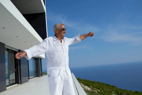 Uomo anziano di fronte alla casa moderna — Foto Stock