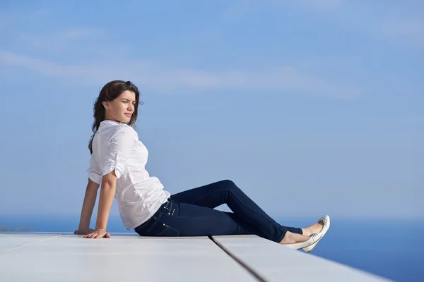 Mulher relaxada na frente da casa moderna de luxo — Fotografia de Stock