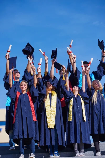 Gymnasiasten werfen Hüte hoch — Stockfoto