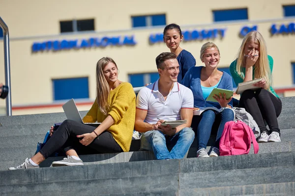 Studenten sitzen draußen auf Stufen — Stockfoto