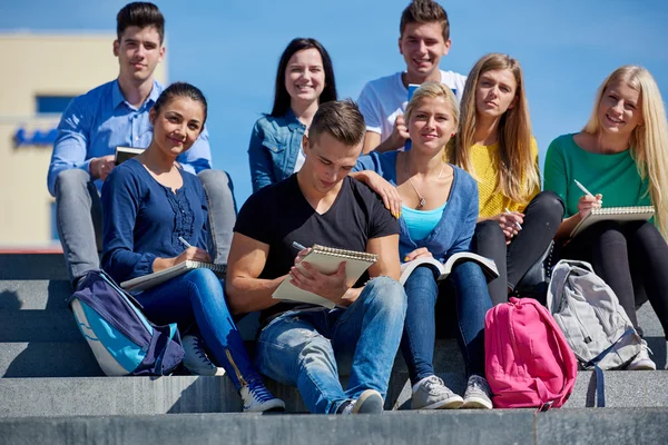 Studenti fuori seduti su gradini — Foto Stock