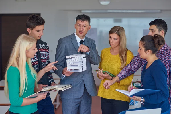 Grupo de alunos que trabalham com o professor — Fotografia de Stock