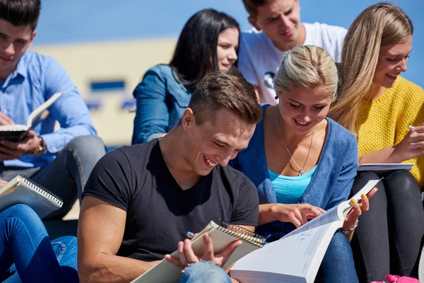 Studenti fuori seduti su gradini — Foto Stock