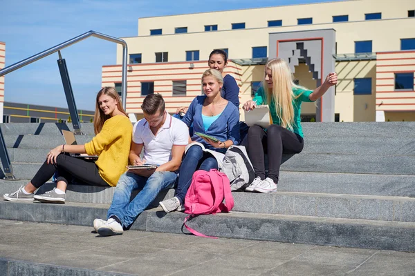 Studenti mimo sedí na schodech — Stock fotografie