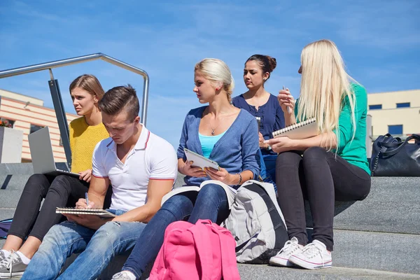 Studenti fuori seduti su gradini — Foto Stock