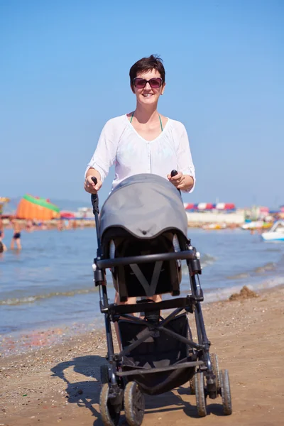 Madre che cammina sulla spiaggia — Foto Stock