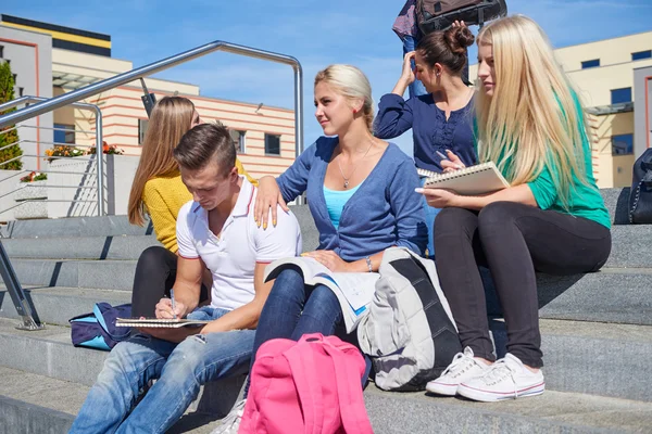 Studenti mimo sedí na schodech — Stock fotografie