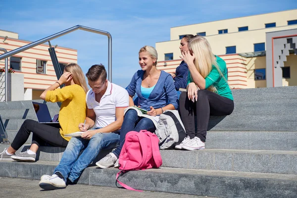Studenci poza siedzący na schodach — Zdjęcie stockowe