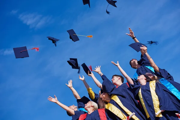 Graduados do ensino médio jogando chapéus — Fotografia de Stock