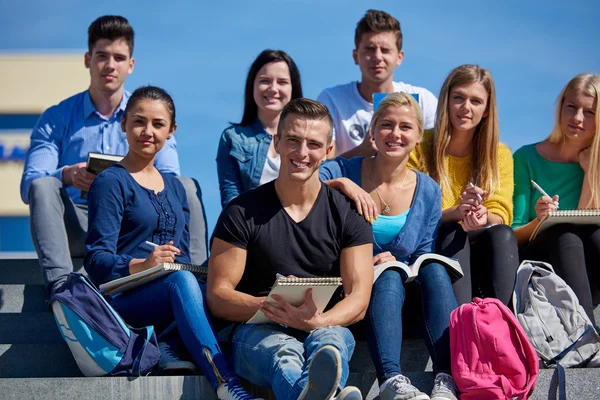 Studenti mimo sedí na schodech — Stock fotografie