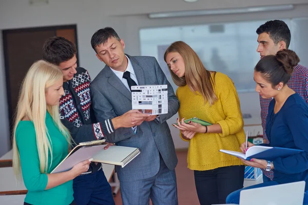 Group of students working with teacher — Stock Photo, Image