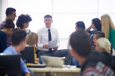 Bilgisayar laboratuarı sınıfta öğretmen öğrencilerle
