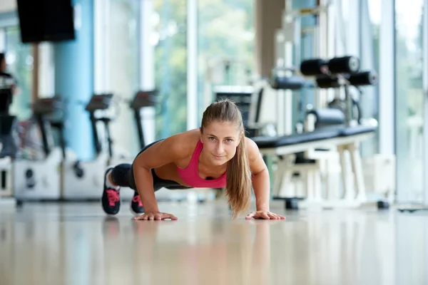 Kvinnan gör några armhävningar på gymmet — Stockfoto