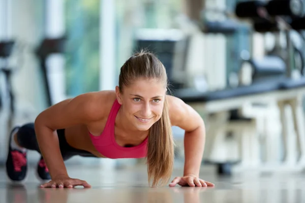 女人做一些俯卧撑在健身房 — 图库照片