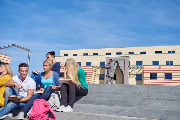 Students outside sitting on steps — Stock Photo, Image