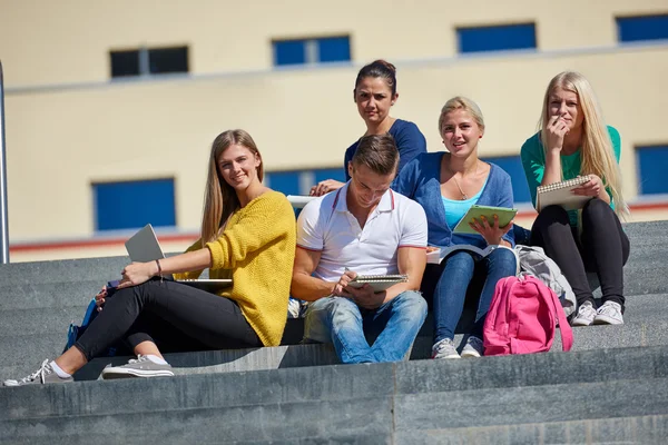 Студенты снаружи сидят на ступеньках — стоковое фото