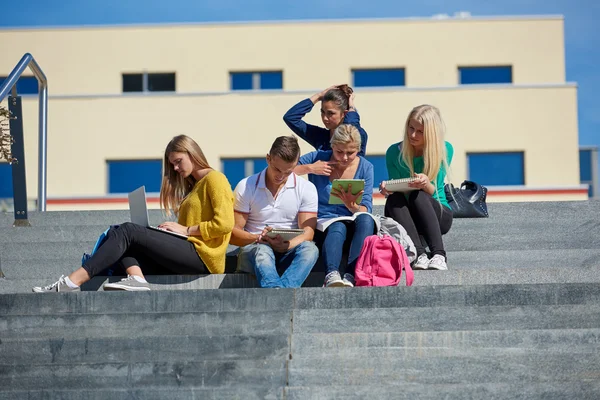 Estudiantes fuera sentados en escalones — Foto de Stock