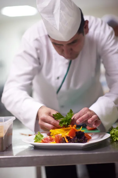 Chef na cozinha preparando e decorando alimentos — Fotografia de Stock