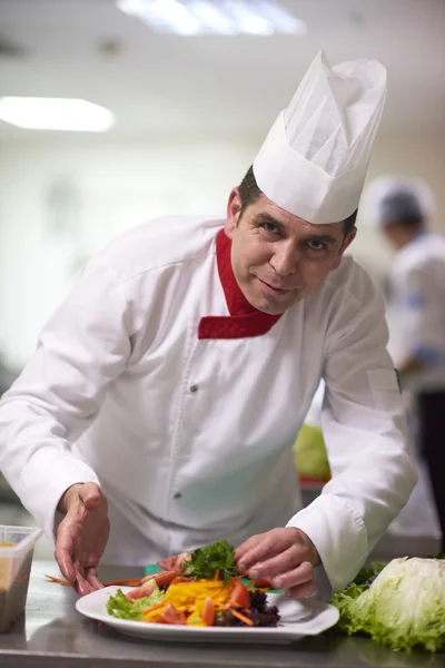 Chef na cozinha preparando e decorando alimentos — Fotografia de Stock